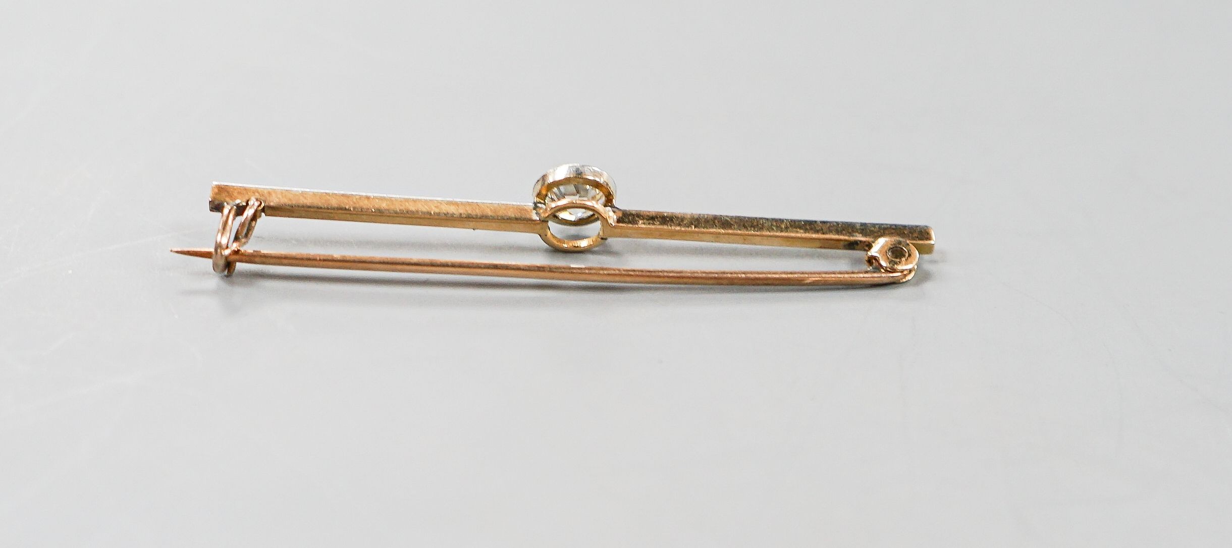 An early 20th century yellow metal and solitaire diamond set bar brooch, 57mm, gross weight 4.3 grams